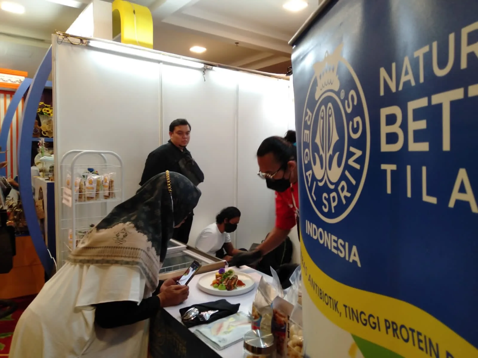 Salah satu warga melihat dengan seksama kuliner berbasis ikan Tilapia di booth Regal Springs Indonesia dalam acara Kriya Fest yang diadakan di Tiara Convention Center, Medan, Selasa-Kamis (21-23/2/2023).