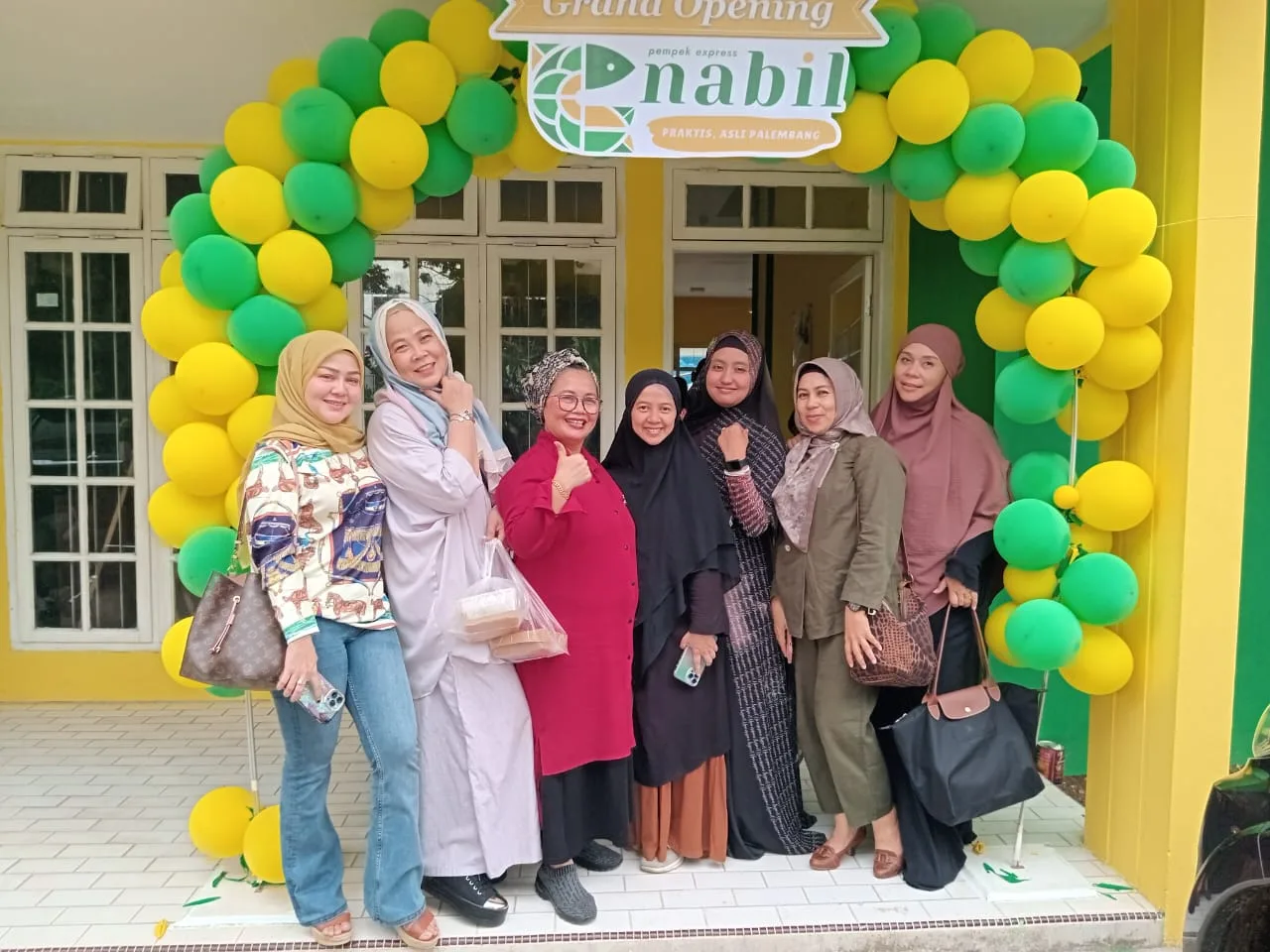 Widyawati (tengah) saat berfoto bersama sejumlah pelanggan setia Pempek Nabil, Jumat 19 Mei 2023.