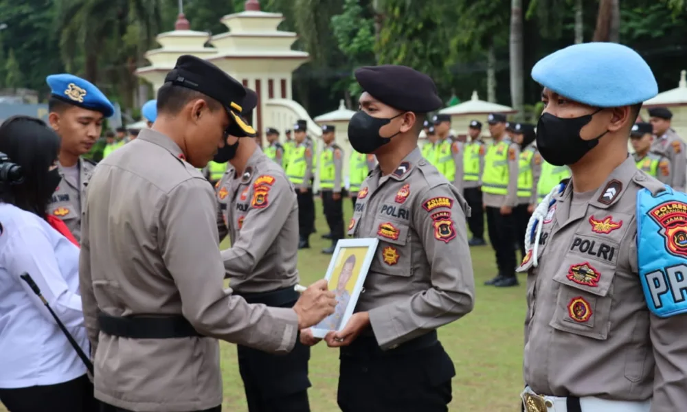 Kapolres Merangin mencoret dua foto personel Polres Merangin yang kena PTDH. (DETAIL/ist)