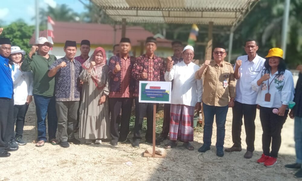 Asisten 1 Provinsi Jambi, Arif Munandar berfoto bersama usai menyerahkan sapi kurban dari Presiden Joko Widodo kepada pengurus Masjid Baiturrahman Desa Tambang Emas. (DETAIL/Daryanto)