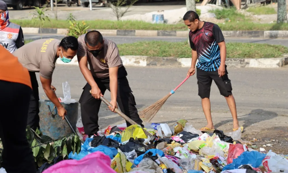 Personel Polres dan Sabrimobda Polda Jambi, turun membersihkan tumpukan sampah di kota Bangko. (DETAIL/ist)
