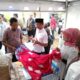 Kepala OJK KR 5 Sumbagut, Bambang Mukti Riyadi (batik merah) mendapatkan penjelasan soal batik motif desa wisata Pematang Johar yang berbahan baku tanaman manggrove dari Kades Pematang Johar, H. Sudarman, Rabu 9 Agustus 2023. (DETAIL/Heno).