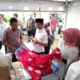 Kepala OJK KR 5 Sumbagut, Bambang Mukti Riyadi (batik merah) mendapatkan penjelasan soal batik motif desa wisata Pematang Johar yang berbahan baku tanaman manggrove dari Kades Pematang Johar, H. Sudarman, Rabu 9 Agustus 2023. (DETAIL/Heno).