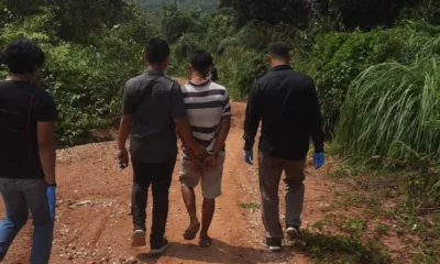 Terduga pelaku pembunuhan berkaos hitam putih saat rekonstruksi di lokasi pembunuhan. (DETAIL/ist)