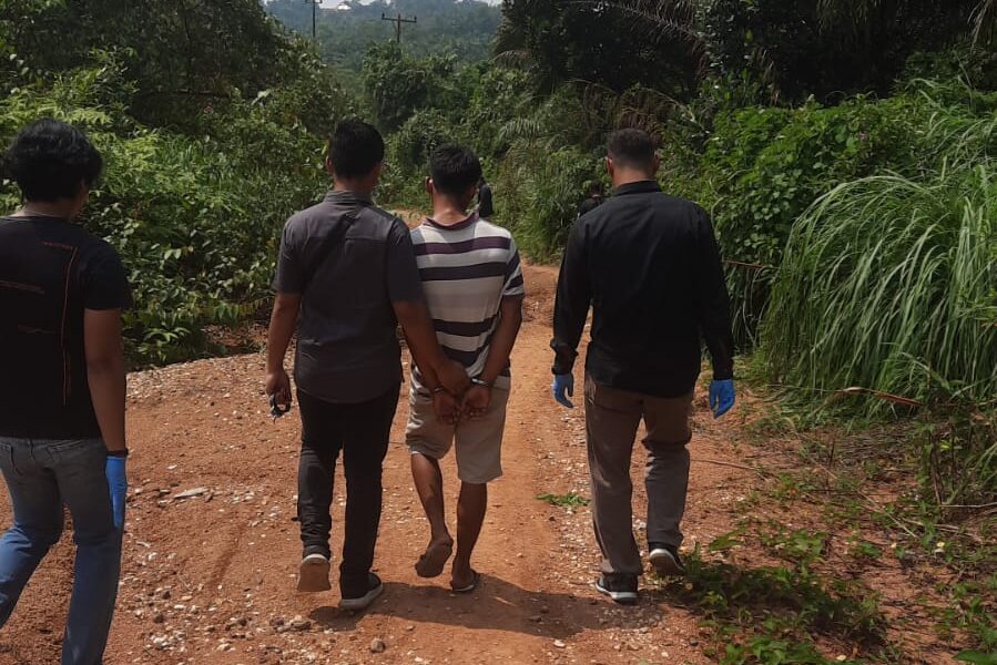 Terduga pelaku pembunuhan berkaos hitam putih saat rekonstruksi di lokasi pembunuhan. (DETAIL/ist)