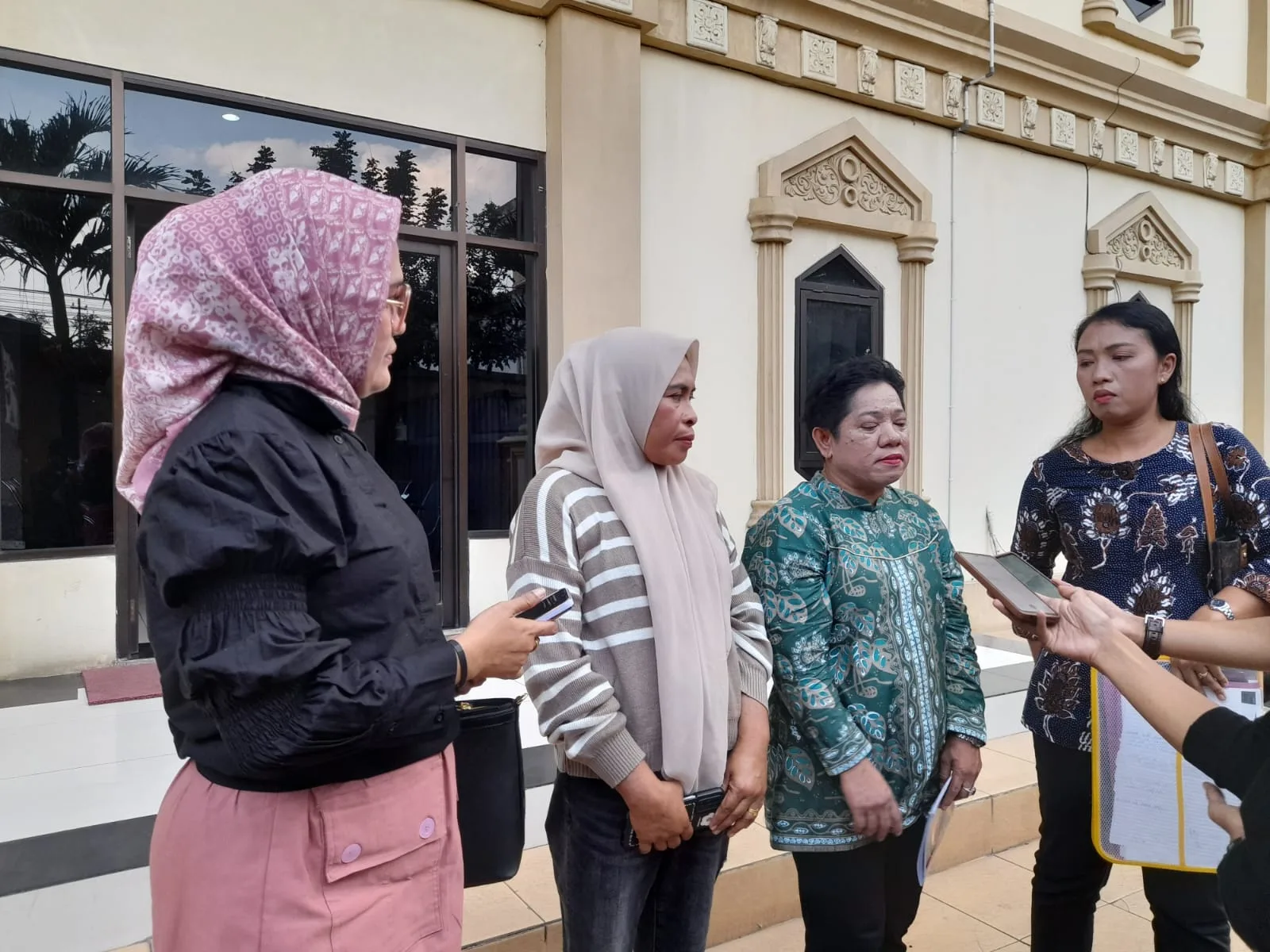 Rusmiati (kedua dari kiri, jilbab coklat) didampingi kuasa hukumnya usai pemeriksaan di Polda Jambi. (DETAIL/Juan)