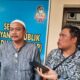 Iskandar (kopiah putih) usai laporkan CV Karo-karo. (DETAIL/ist).