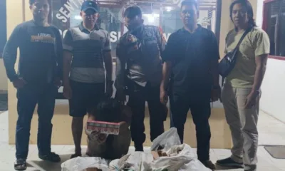 Pelaku pencurian toko sembako, terduduk di depan Polsek sungai Manau dengan bukti kejahatannya.(DETAIL/ist)