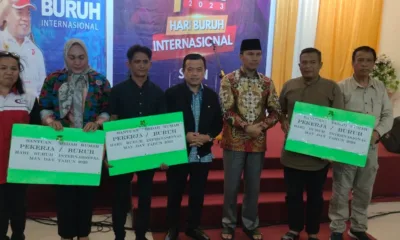 Tiga buruh saat menerima simbolis program bedah rumah pada 1 Mei 2023. Turut hadir Kadisnakertrans, Bahari Panjaitan (paling kanan). (DETAIL/ist)