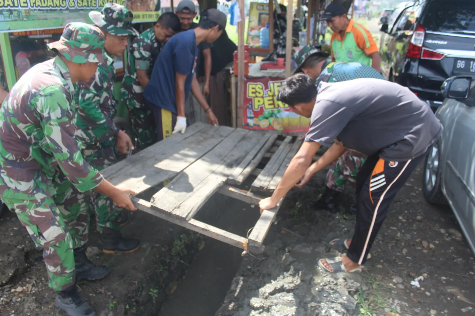 Anggota Kodim Sarko bersama masyarakat membersihkan drainase dan menanam pohon. (DETAIL/ist)