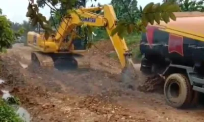 Alat berat milik PT SAL mendorong mobil berisi CPO yang terbenam di dalam kubangan lumpur. (DETAIL/ist)