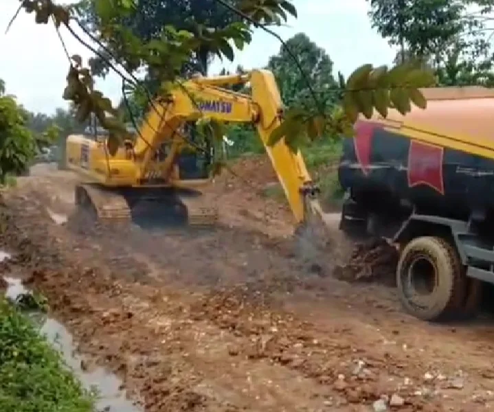 Alat berat milik PT SAL mendorong mobil berisi CPO yang terbenam di dalam kubangan lumpur. (DETAIL/ist)