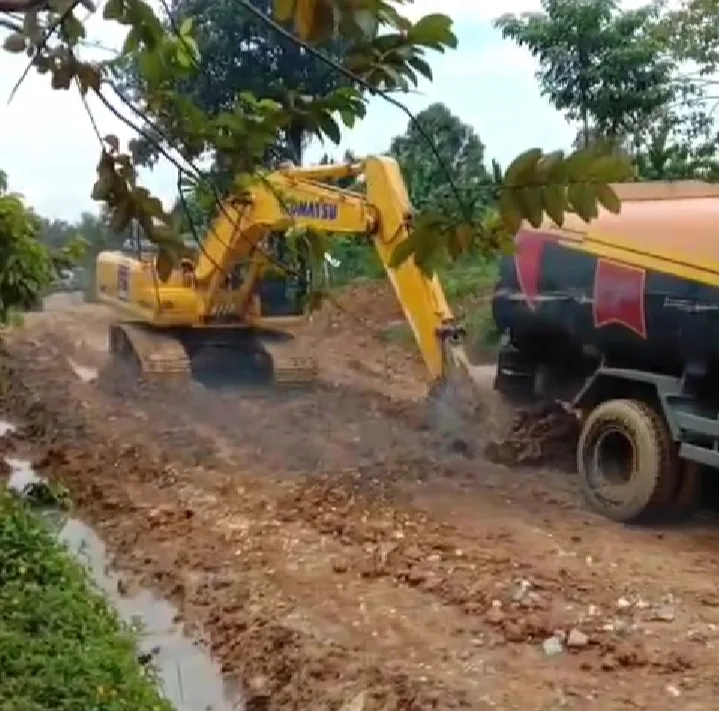 Alat berat milik PT SAL mendorong mobil berisi CPO yang terbenam di dalam kubangan lumpur. (DETAIL/ist)