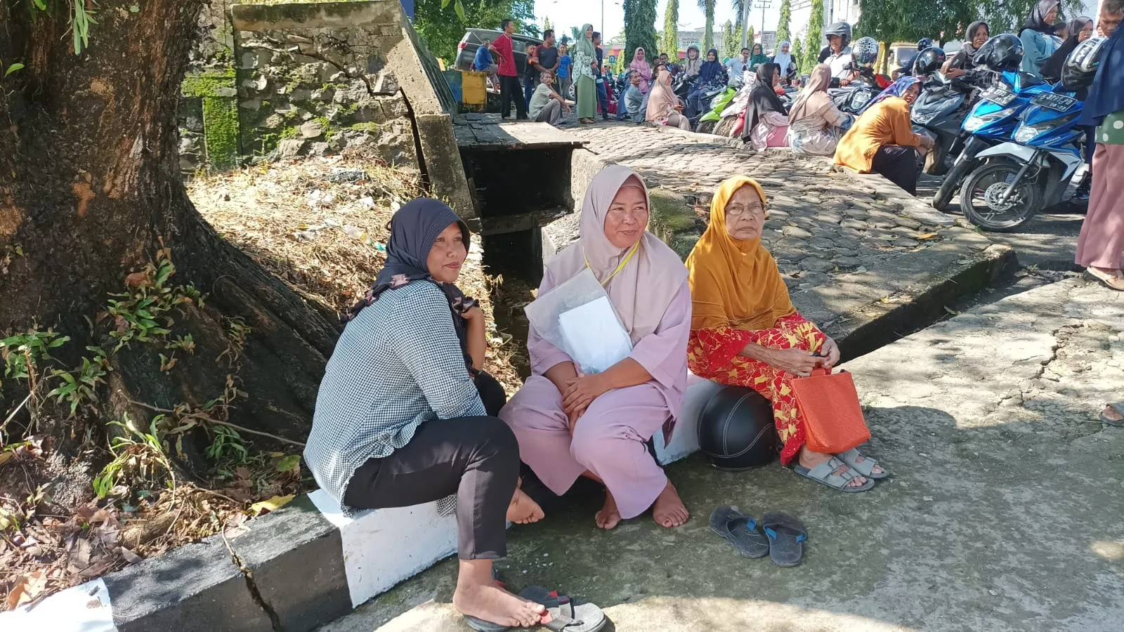 Kerumunan ibu-ibu penerima bantuan pangan yang terlihat kecewa dengan penundaan kunjungan Presiden Jokowi di Merangin. (DETAIL/Daryanto)