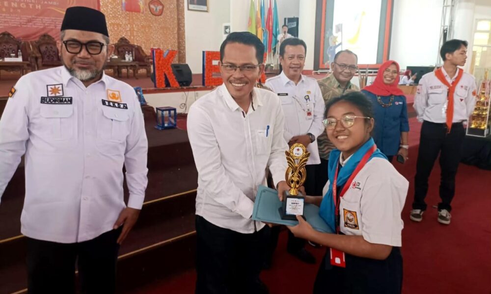 Emelia Sirait saat menerima piala penghargaan dari rektor Unja (DETAIL/Jorgi)