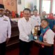 Emelia Sirait saat menerima piala penghargaan dari rektor Unja (DETAIL/Jorgi)