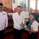 Emelia Sirait saat menerima piala penghargaan dari rektor Unja (DETAIL/Jorgi)
