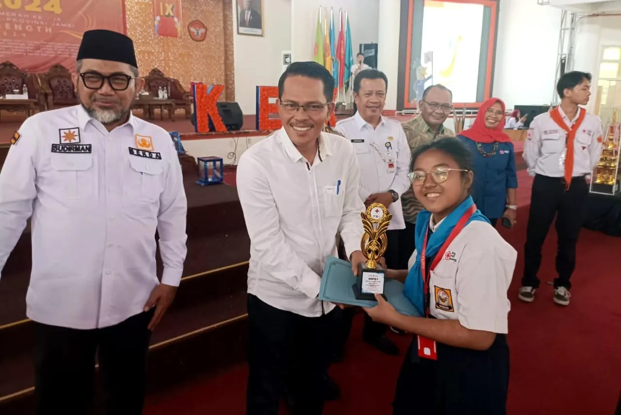Emelia Sirait saat menerima piala penghargaan dari rektor Unja (DETAIL/Jorgi)