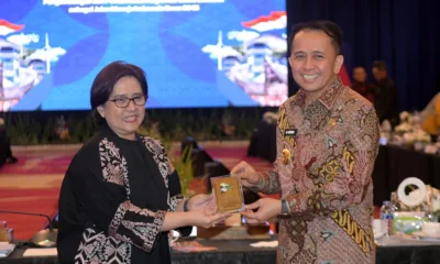 Pj Gubsu, Agus Fatoni menyerahkan plakat penghargaan kepada Sekretaris Bappenas, Terry Widuriyanti. (ist)