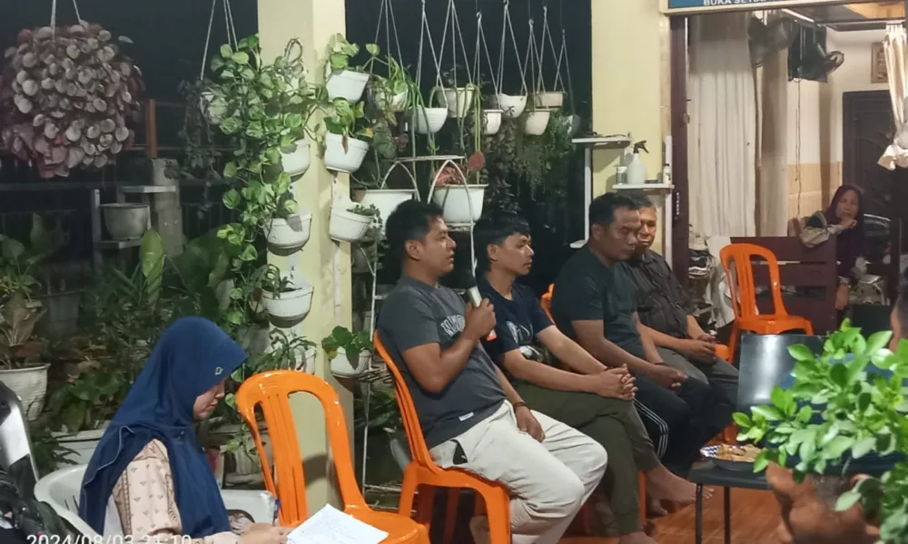 Nanda Lexmana (pegang mikrofon) dalam musyawarah 3 RT. (DETAIL/Juan)