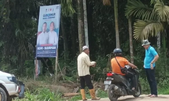 Oknum Lurah (baju biru) yang nekat pasang baliho RH. (ist)