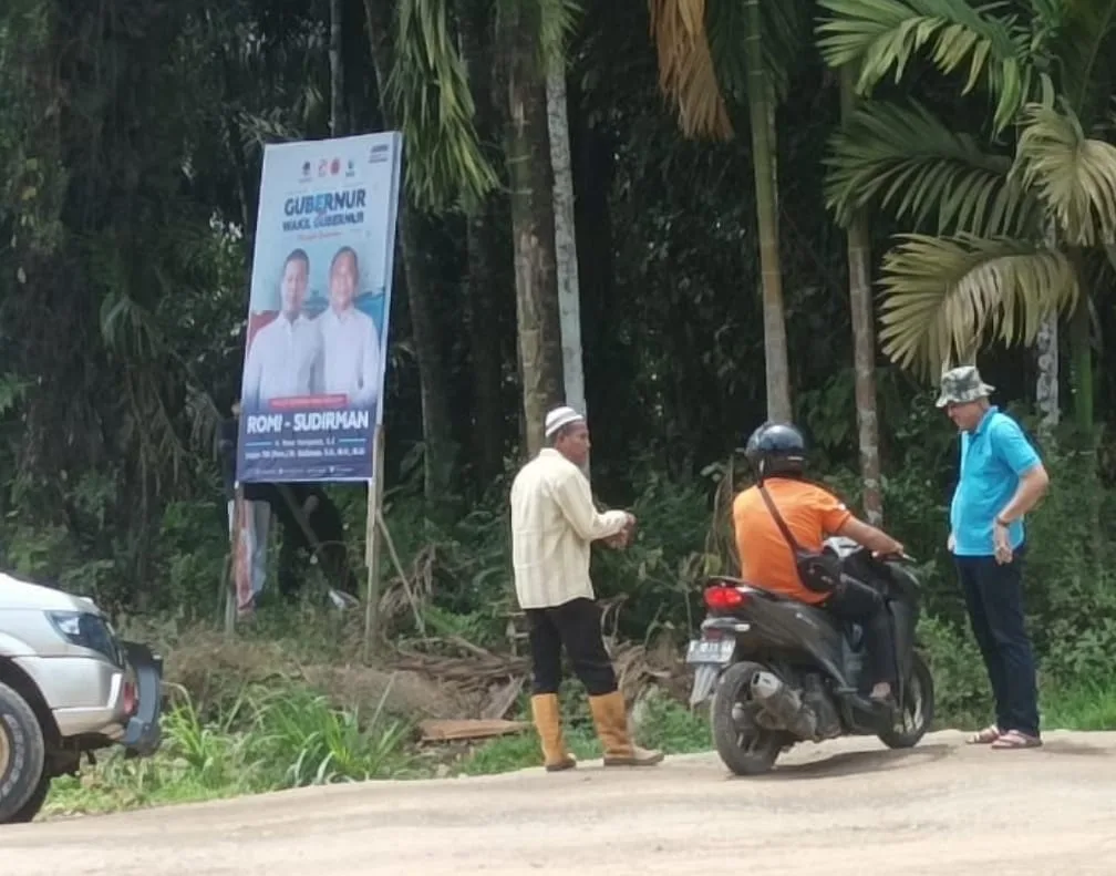 Oknum Lurah (baju biru) yang nekat pasang baliho RH. (ist)