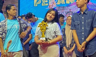 Dewi Mora Manalu saat menerima piala pada pekan pesona budaya. (DETAIL/ist)