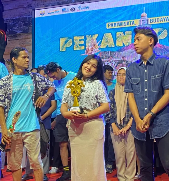 Dewi Mora Manalu saat menerima piala pada pekan pesona budaya. (DETAIL/ist)