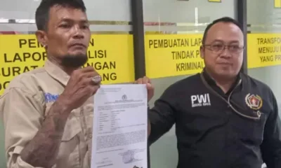 Charles (44) didampingi Ketua PWI Bekasi Raya memperlihatkan bukti laporan Polisi