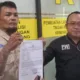 Charles (44) didampingi Ketua PWI Bekasi Raya memperlihatkan bukti laporan Polisi