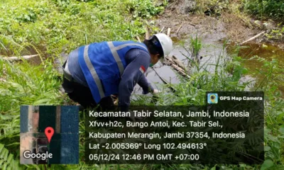 Petugas dari Dinas Lingkungan Hidup Merangin saat mengambil sampel air di parit milik warga. (DETAIL/Daryanto )