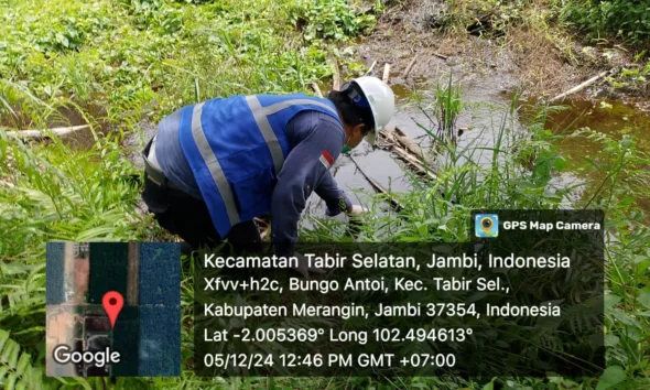 Petugas dari Dinas Lingkungan Hidup Merangin saat mengambil sampel air di parit milik warga. (DETAIL/Daryanto )