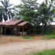 Rumah keluarga Sawal, hanya berjarak lima meter dari dinding kolam limbah PT SGN yang tak tersentuh bantuan apapun oleh perusahaan. (DETAIL/Daryanto)