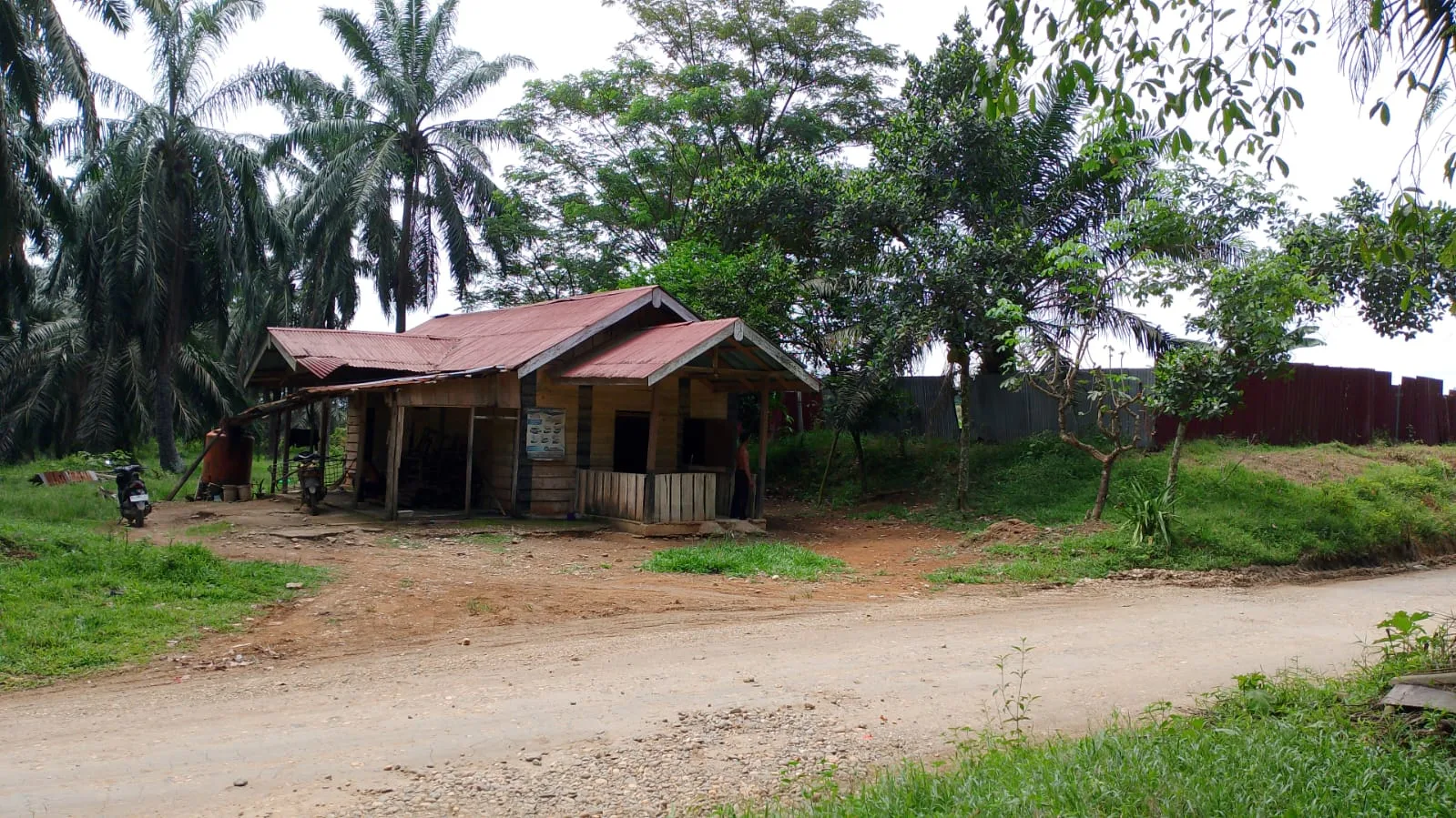 Rumah keluarga Sawal, hanya berjarak lima meter dari dinding kolam limbah PT SGN yang tak tersentuh bantuan apapun oleh perusahaan. (DETAIL/Daryanto)